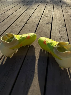 Nike gula fotbollsskor med strumpkrage - Säljer mina Nike Phantom 6 Pro High Cut FG “Max Voltage” i grön/svart/orange ⚽🔥 Storlek 36  Skorna är endast använda max 3 gånger då de tyvärr varit lite för små för mig. Annars är de verkligen supersköna och sitter fantastiskt på foten!  Nike Phantom 6 är framtagen för precision, grepp och snabbhet på planen och används bland annat av Erling Haaland och flera elitspelare 🌟