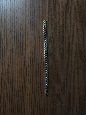 stainless steel kedjearmband 19cm - Säljer ett stilrent armband i silverfärgad metall med breda, platta länkar och klassiskt lås. Perfekt för dig som gillar minimalistisk och modern design. Armbandet har en chunky känsla och passar snyggt på handleden.