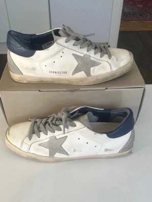 Golden Goose vita sneakers med grå stjärna - Säljer inte här på plick. Jag har inte skorna själv. Du betalar mig och ger mig din adress och sånt och sen beställer jag den till dig. 