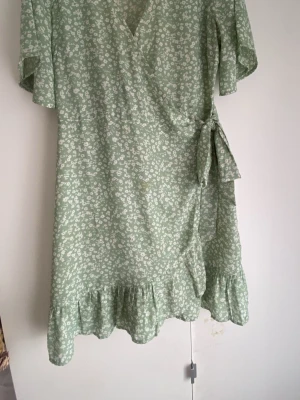 Grön omlottkläning med vita små blommor på! - Slutar vid knäna(är 1,67 m), ärmarna slutar vid armbågarna. Funkar som L, rätt så lös på ❣️