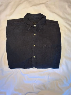 Vintage Ralph Lauren | Skjorta | L - Klassisk svart skjorta från Polo Ralph Lauren med vit knappstängning och bröstficka. Skjortan har lång ärm och är tillverkad i bomull, perfekt för en stilren look. Mått: Längd 73 Bredd 58
