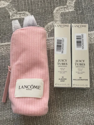 Lancôme Juicy Tubes Läppglans Duo + borstset - Säljer två Lancôme Juicy Tubes Original läppglans i färgerna 16 Almond Drip och 09 Hallucination. Kommer i snygga förpackningar och med en rosa tygnecessär med dragkedja och Lancôme-logga. Perfekt för dig som vill ha glansiga och återfuktade läppar. Samt nya sminkborstar 