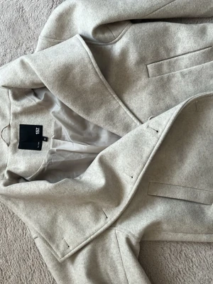 Beige kort Kappa - Beige kappa från lager 157 med knappar hela vägen upp, i bra skick men knapparna kan behövas sys fast lite tajtare och det följer även med en extra knapp till 💕 kappan är medellång/kort och går ungefär ner till höften. Lite smånopprig. 