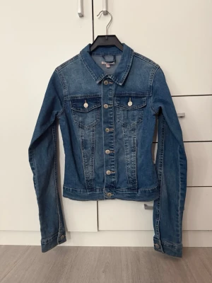 Klassisk blå jeansjacka - Snygg blå jeansjacka i storlek xs en liten fläck på vänster axel men går säkert enkelt bort med lite kärlek! Super fin!