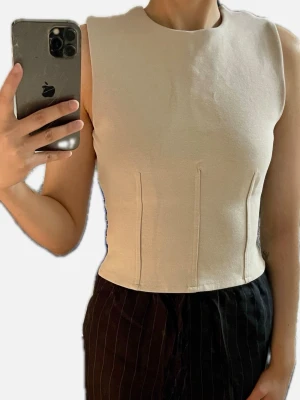 Snygg boatneck tanktop - Ärmlös topp med båtringning- har figurnära passform med dragkedja baktill.