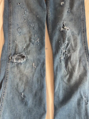 Ljusblå slitna jeans med hål - Pris går att diskuteras vid snabb affär Säljer ett par ljusblå jeans med flera slitningar och hål, de är från pepe jeans storlek w27. Jag uppfattar de som lowaist då de sitter långt under naveln men de står mid waist på de. Passar S. Har bara testats 