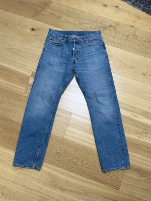 Blå raka jeans Weekday - Säljer ett par blå jeans med rak passform och klassisk femficksdesign.  Straight fit, storlek 30 midja, 32 längd
