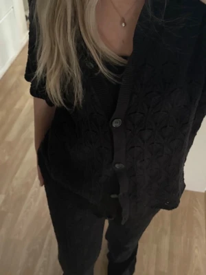 Svart virkad kofta med kort ärm , samma byxor - Säljer detta jätte fina sett ifrån NAKD, storlek S men är väldigt stretchigt så passar en M oxå! Väldigt långa ben på 🖤 Jag själv är 173 cm och trampar på byxorna. Men snyggt att ha som det är eller över en bikini. 