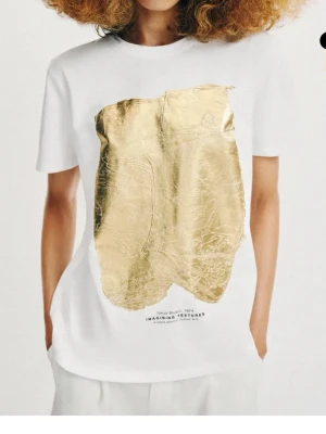 T-shirt - Vit T-shirt med guld tryck, såå snygg och andvändbar. Helt ny och aldrig andvänd pga fel storlek🙌🏼