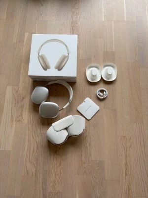 Apple AirPods Max over-ear hörlurar - Snygga over-ear hörlurar från Apple i silver/vit färg. Kommer med originalförpackning, laddkabel, skyddsfodral och öronkuddar. Tillverkade i aluminium och mjukt material för komfort. Perfekta för musik, gaming eller film.