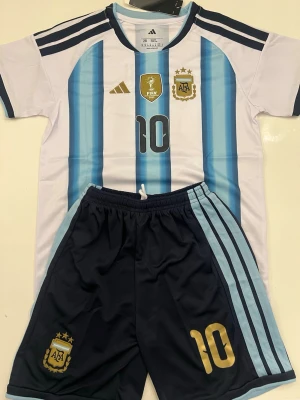 Lionel Messi Argentina Vm 2026 Barnset - Fotbollströja och shorts i helt nytt och oanvänt skick med tag kvar. Detaljrik design och bekvämt material som passar både till match och vardag. Detta är en inofficiell version av modellen. passar cirka 158–160 cm.
