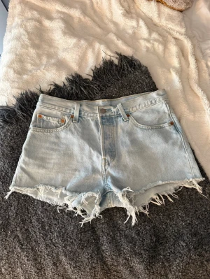 Ljusblå Levi's jeansshorts  - Säljer ett par ljusblå jeansshorts från Levi's. Shortsen har en liten fläck vid fickan som syns på tredje bilden annars är de i superfint skick. 