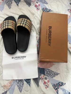 Burberry  tofflor - Snygga tofflor från Burberry som är helt nya och oanvända och säljer de pågrund av att de är små.