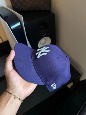New Era fitted keps  - Yo, säljer denna lila fitted keps. Kepsen är i jätte bra skick och är i storlek 57.7cm och är en hyfsad ”standard” storlek 