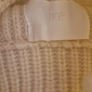 Vit ribbstickad tröja - Säljer en stilren vit ribbstickad tröja med lång ärm. Tröjan har en klassisk rund halsringning och är gjord i ett mjukt, tjockt material som passar perfekt för kyligare dagar. Enkel och clean design som är lätt att matcha med olika outfits.