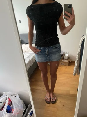 Svart tight topp med båtringning - Svart topp med korta ärmar och båtringningen. Modellen är figurnära och materialet är soft touch❣️