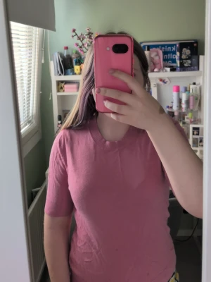 Rosa kortärmad tröja - En enkel och snygg rosa tröja med korta ärmar och rund hals. Tröjan har ribbade muddar vid hals, ärmslut och nederkant. Perfekt för dig som gillar en basic men färgglad stil.