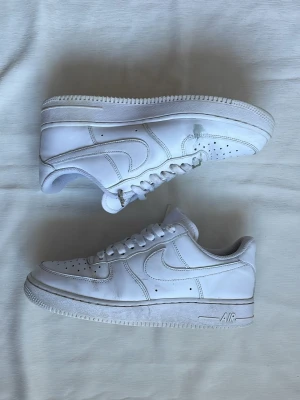 Nike Air Force 1 vita | 41 - Nike Air Force 1 | Strl: 41 | Skick: Dubben längst ut på skosnöret är trasigt, det finns också en fläck på insidan av båda skorna (se bild 3) Hör av dig vid funderingar⁉️
