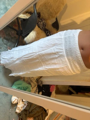 Vit långkjol med resårmidja - Säljer en enkel och luftig vit långkjol med bred resår i midjan. Kjolen är gjord i ett tunt,  bomullstyg som ger en avslappnad känsla. 