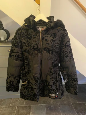 Svart mönstrad pufferjacka Desigual - Säljer en svart pufferjacka från Desigual med unikt sammetstryckt mönster, päls på huvan och detaljer som bälte i midjan och dragkedja. Om ni vill lägga bud eller har någon fråga så tveka inte på att höra av er! 