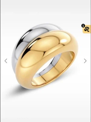 Tvåfärgad chunky ring i metall - Snygg chunky ring i både guld- och silverfärgad metall. Ringen har en rundad, bred design som ger ett modernt och trendigt intryck. Perfekt för dig som gillar att mixa metaller och vill ha ett statement-smycke.