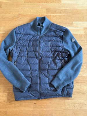  Moncler cardigan grå - Säljer min Moncler cardigan i storlek L men passar som en M. En söm har börjat gå upp lite som ni ser på 3de bilden annars inga defekter. Ägt den i ungefär 1 år kvitto saknas. Säljer pga för kort i längd för mig. Min längd är 183 och väger 68kg tveka ej att skriva vid intresse