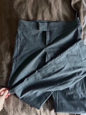 Mörkgrå kostymbyxor från Nelly - Snygga mörkgrå kostymbyxor från Nelly med bootcut passform och  mid waist. .