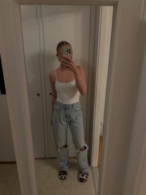 Ljusblåa ripped jeans från Gina - Säljer ett par ljusblåa jeans från Gina i storlek 36(Innerbenslängd 77cm) med hög midja och raka ben. Jeansen har slitningar på knäna och klassiska femficksdetaljer. Materialet är denim och passformen är loose fit. Perfekta för en avslappnad och trendig look.