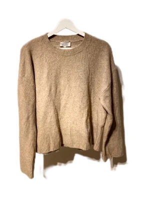 Beige stickad tröja från & Other Stories - Säljer en beige stickad tröja från & Other Stories Paris Atelier. Tröjan har rund hals, ribbade muddar vid ärmslut och nederkant samt långärmad passform. Perfekt för lager-på-lager och chill höst- och vinterstil.