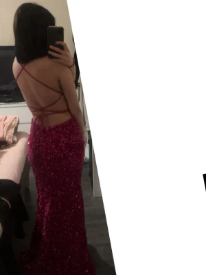 Vinröd/rosa glittrig långklänning - Säljer en vinröd långklänning med glittrigt tyg och figurnära passform. Klänningen har öppen rygg med tunna korsade band och är ärmlös. Perfekt för bal eller festliga tillfällen när du vill sticka ut. Använd en gång bara