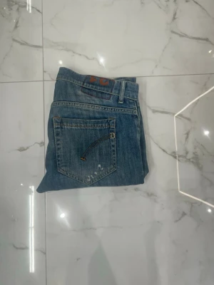 Dondup George  - Dondup jeans         modell: George      Skick: 8/10  Färg: Blå.         Pris:699kr.                                      ända defekten är att läder lappen på insidan av jeansen har tagit lite stryk under tvätt.