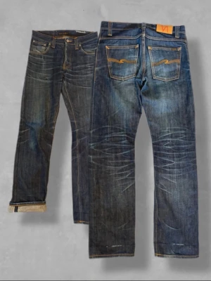 Nudie jeans - Average Joe 29/32 - Säljer ett par legendariska Nudie Jeans i modellen Average Joe, tillverkade i deras högkvalitativa Dry Selvedge-denim.  Detta exemplar är en dröm för denim- entusiasten. De är inburna under lång tid och har utvecklat en helt unik, naturlig patina (fades) som man bara får genom hantverket att bära in japansk selvedge. Rejäla kontraster vid knän (honeycombs) och framsida lår (whiskers).  Modell: Average Joe (Straight leg / Rak passform)  Storlek: W29 L32  Tyg: Kraftig japansk selvedge-denim med de
