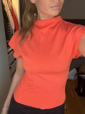 Koralorange ribbad topp - Trendig koralorange topp med korta ärmar och hög hals. Från HM, använd fåtal gånger 
