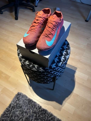 Nike Mercurial 16 Elite Mad energy pack  - Säljer ett par Nike Mercurial fotbollsskor som jag använt till och från under förra säsongen. Skorna är hela och funkar helt klart att använda. Det finns inga skador på dem men det syns att dem är använda. Skriv vid fler frågor! 