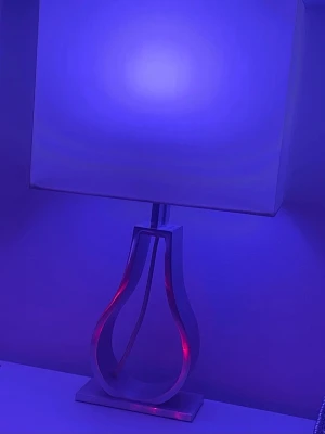 Modern bordslampa med metallfot - Säljer en modern bordslampa med fyrkantig vit lampskärm och dekorativ metallfot i böjd form. Lampan har en stilren design som passar perfekt på skrivbord eller nattduksbord. Skärmen ger ett mjukt ljus och lampfoten har en unik, öppen struktur.