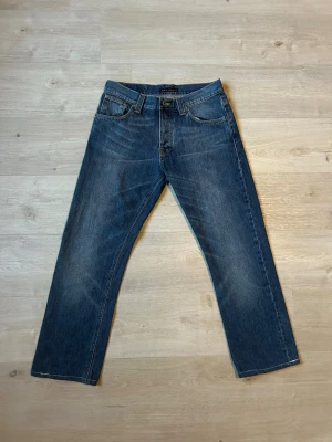 Blåa Nudie Average Joe Jeans W31 L34 - Fina Nudie Jeans i blå färg. Jeansen är i mycket bra skick men är lite små i storlek (längden) då de har blivit omsydda (SE SISTA 2 BILDER) och sparsamt använda. |  Äkta som allt annat jag säljer! ✅ |  Storlek: W31 L34 -  (SE SISTA 2 BILDER) | Skick: Mycket Bra Skick | Färg: Blå | Märke: Nudie | Modell: Jeans |  Hör gärna av dig vid frågor så svarar jag så fort jag kan! 😁|   (Sku - 30)