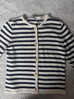 Randig kofta med guldiga knappar  - Säljer en creme färgad kofta med mörkblå ränder och guldiga knappar från mango. Jättefint skick. Storlek M, men sitter som en XS/S.