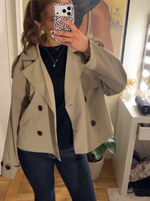 Kort beige trenchcoat  - Säljer en snygg kort trenchcoat i beige färg med dubbelknäppning framtill. Köpt på Zalando för ett tag sen💓