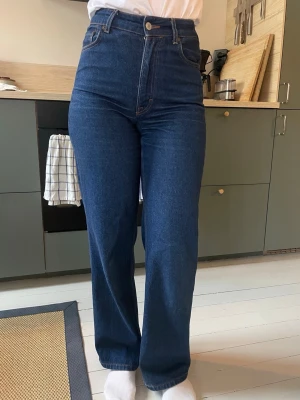 Mörkblå raka jeans från Dagmar - Säljer ett par mörkblå jeans från Dagmar med rak passform och hög midja. Klassisk femficksmodell i kraftig denim. Tyvärr är de lite för små för mig - annars älskar jag modellen och färgen! Storlek 28/32 men tycker de är ganska små jämfört med 28 hos vissa andra jeansmärken. Skriv så kan jag skicka mått. 
