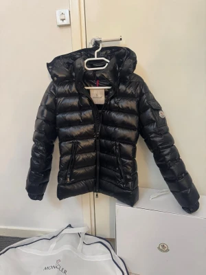 Svart dunjacka från Moncler - Snygg svart dunjacka från Moncler model bady. Den passar xs/s och är i jättefint skick. Den har nfc, taggar, scann, qr kod. 