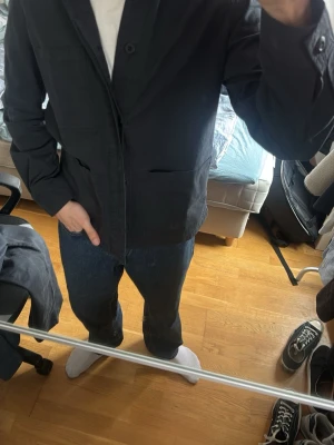 Marinblå overshirt med fickor - Säljer en stilren marinblå overshirt med klassisk krage och stora frontfickor. Jackan har knäppning framtill och är tillverkad i ett slätt, lite kraftigare tyg som ger en clean look. Perfekt att slänga över en t-shirt för en enkel men snygg outfit.