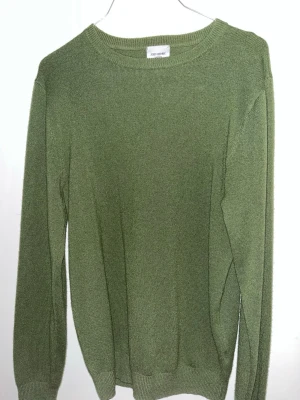Olivgrön cashmere-tröja John Henric - Säljer en stilren grön/olivgrön tröja från John Henric i mjuk cashmere. Tröjan har rund halsringning, långa ärmar och ribbade muddar vid ärmslut och nederkant. Perfekt för dig som gillar klassisk och enkel stil. Säljer då jag växt ut den, är 186cm