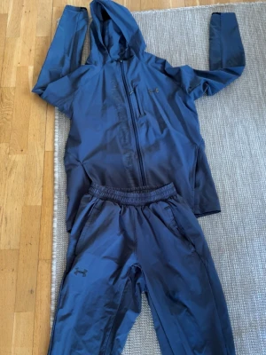 Blått träningsset från Under Armour - OBS byxorna har sytts av skräddare och hoodie har ett litet hål vid axeln 