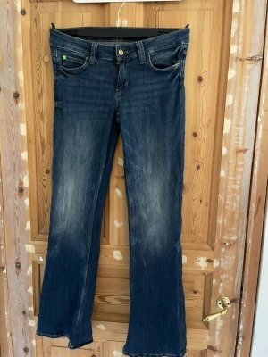 Mörkblå bootcut jeans Cheap Monday - Snygga mörkblå bootcut jeans från Cheap Monday med klassisk femficksmodell och slitningar bakt. Men inget som syns vid användning.Jeansen har en grön etikett bak i midjan och är tillverkade i denim med lätt stretch. Perfekta för en avslappnad och trendig look. Pris kan diskuteras vid snabb affär 