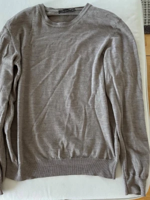 Beige tunn stickad tröja Oscar Jacobson - Snygg beige tröja från Oscar Jacobson i tunn, mjuk kvalitet. Mycket bra skick, som ny och nypris 1400kr.