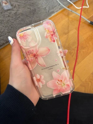 Genomskinligt mobilskal med rosa blommor och en fin text - Snyggt genomskinligt mobilskal med stora rosa blommor och texten 'Everything happens for a reason' på baksidan. Skalets material är plast och det har en mjuk, flexibel känsla. Perfekt för dig som vill ha ett skal som sticker ut och skyddar mobilen.