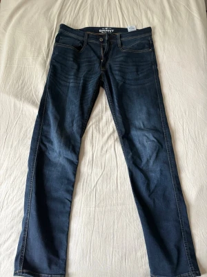 Mörkblå jeans från Grant - Snygga mörkblå jeans från Grant med klassisk femficksmodell och raka ben. Jeansen har kontrastsömmar och subtila slitningar framtill för en avslappnad look. Tillverkade i mjukt denimtyg som sitter skönt hela dagen.