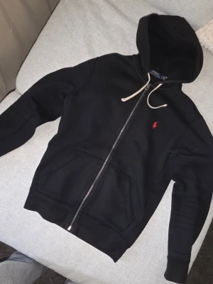 Ralph Lauren Zip-Up Fleece Hoodie – Nyskick - Säljer denna snygga och bekväma zip-up fleece hoodie från Ralph Lauren på grund av viktökning. Hoodien är i toppskick och har endast använts några få gånger. Den har mest legat i garderoben bara..  Skriv gärna vid frågor eller intresse!