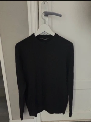 Svart stickad tröja från Primark - En enkel och stilren svart stickad tröja från Primark. Tröjan har rund halsringning och långa ärmar. Perfekt basplagg till garderoben och lätt att matcha med olika outfits.