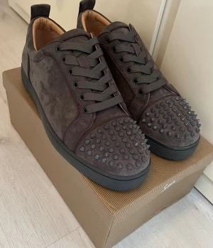 Gråa Louboutin sneakers med nitar - Hallå eller! Säljer nu dessa Christian Louboutin sneakers i storlek 44. Dessa stilrena skor i grått material kommer med box. Ett perfekt tillfälle att skaffa ett par klassiska Louboutins! Skicka ett meddelande om du är intresserad.